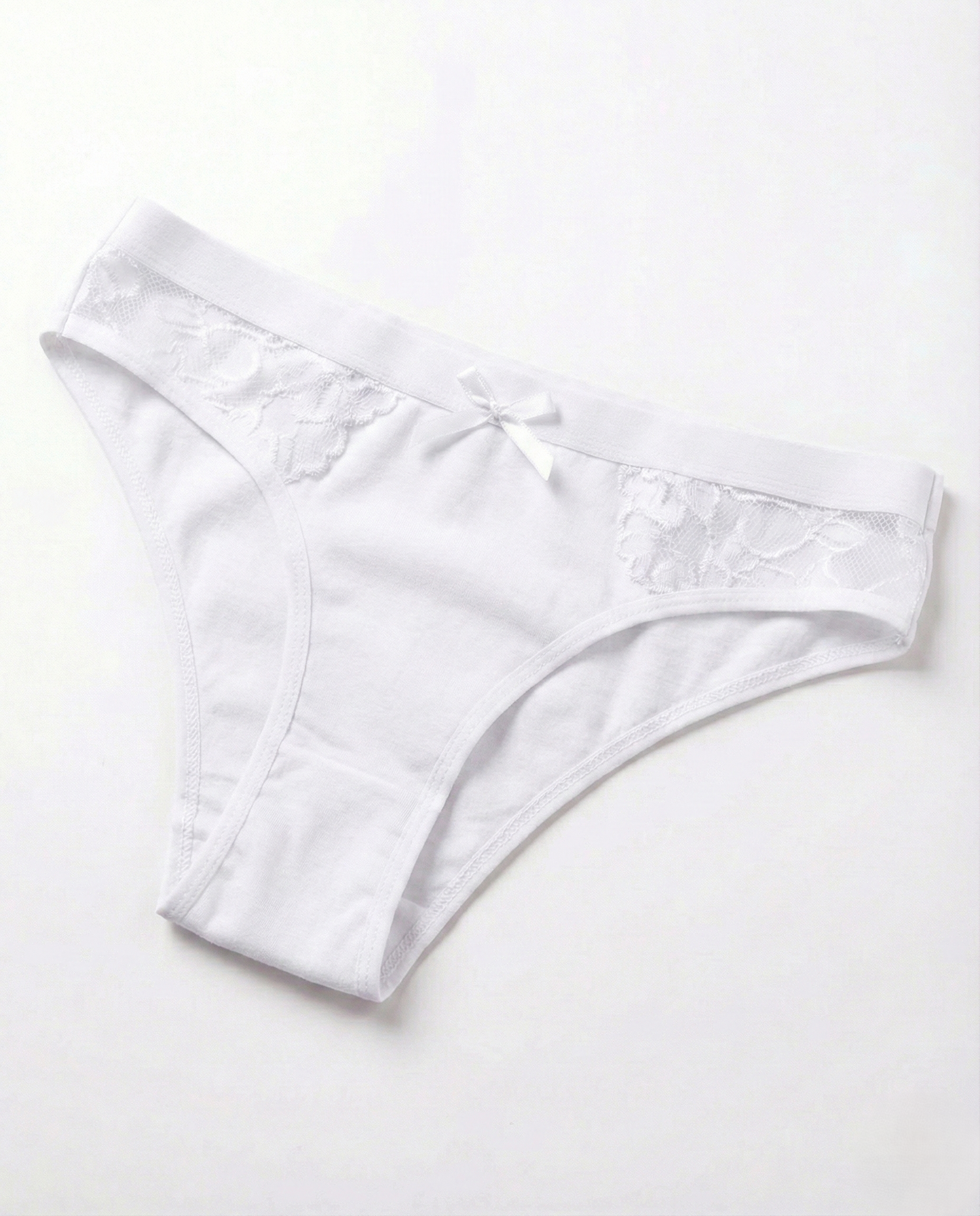 Close-up of low-rise cotton sexy panties with lace trim and mini bow, made from soft stretch cotton blend for natural comfort and flattering fit