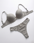 Woman wearing silky seamless lingerie set with floral lace and bow accents, smooth fit and underwire support