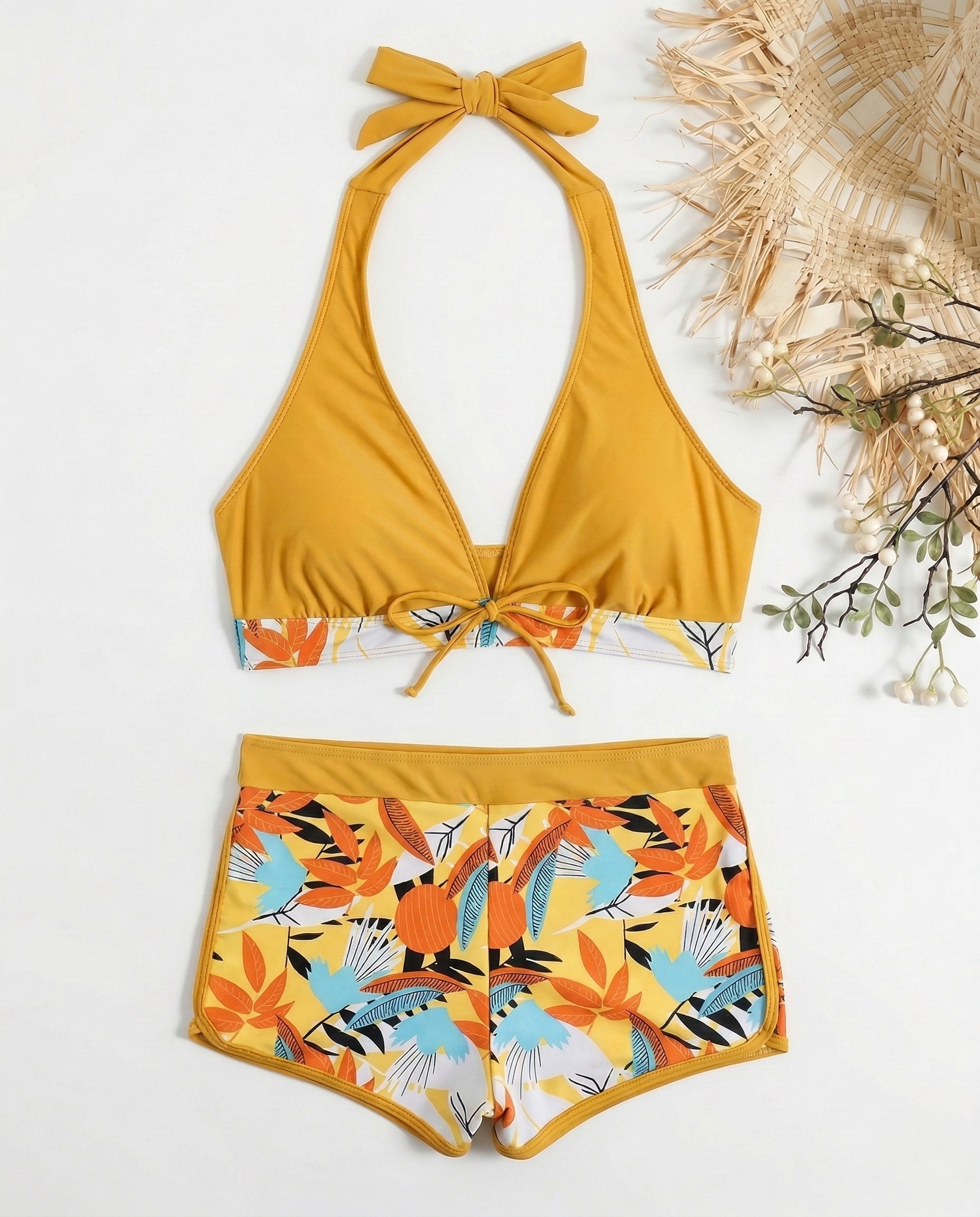 Woman wearing flirty halter bikini with bow detail and botanical print on beach